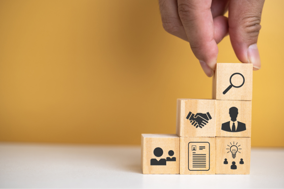 Person stacking wooden boxes with resource icons on them.