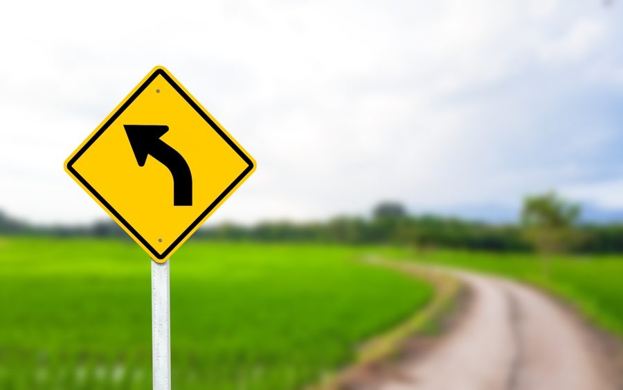 A Black Left-curved Arrow Is Displayed On A Bright Yellow Sign